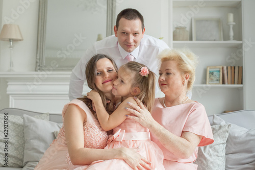 Happy family. Grandmother and mother, daughter, father. Older woman, man, pregnant adult woman and child girl