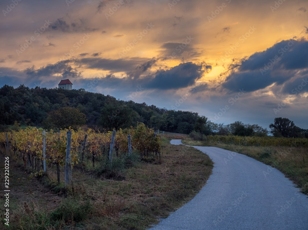 Dramatic Sky at sunset with chapel and Vineyards