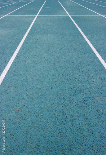 running racetrack with white lines on blue ground