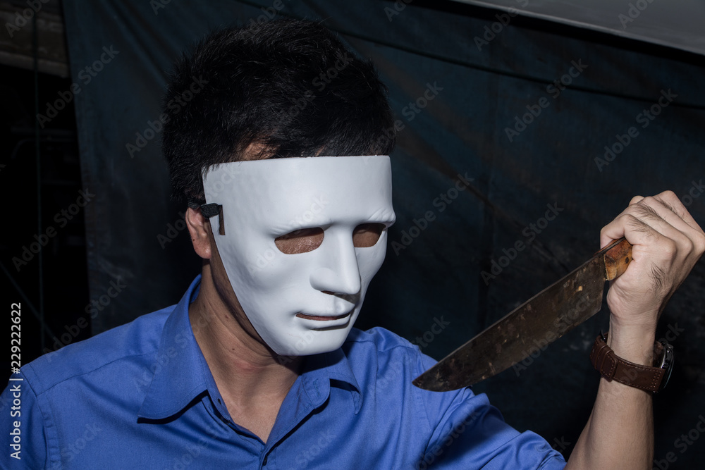 The man in white mask threatens, killer concept, horror theme