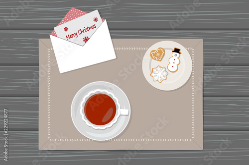 Cup of tea, gingerbread and envelope on napkin