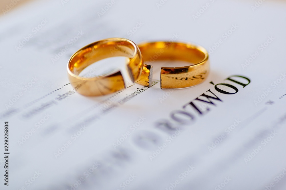 Divorce decree in Polish language and two broken wedding rings - obrazy, fototapety, plakaty 