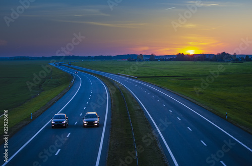 Car driving on the highway at sunset.