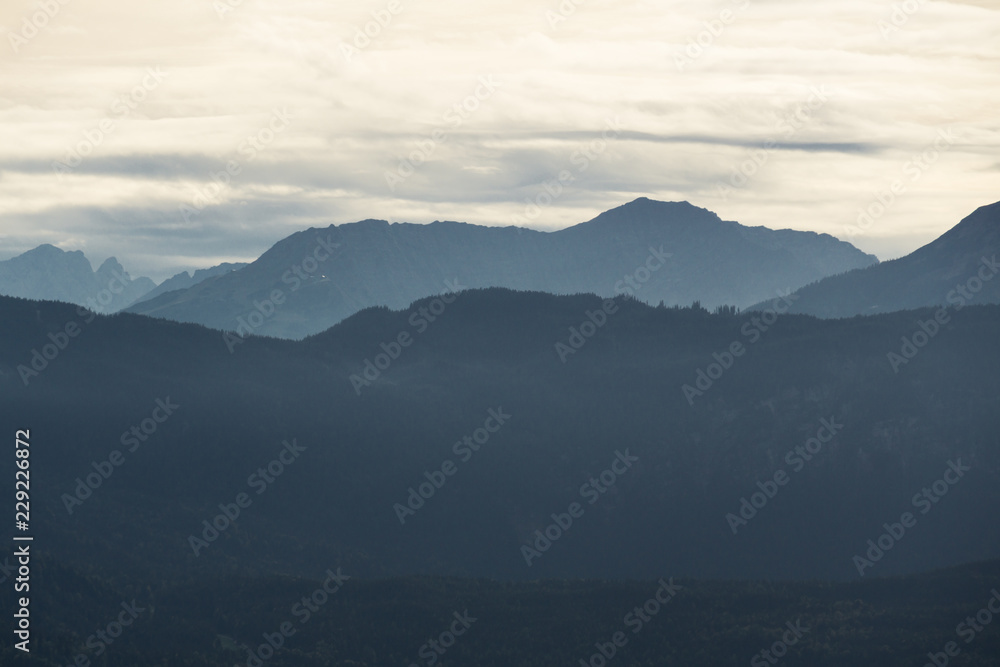 Mountain silhouettes with forest and cloudy sky