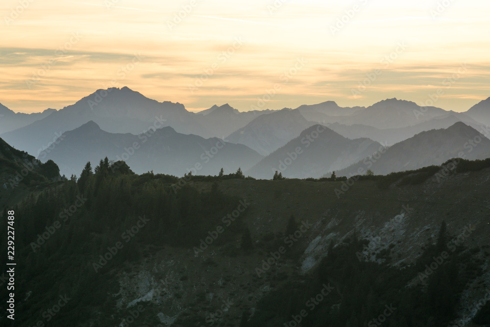 Mountain silhouettes with forest and orange sky