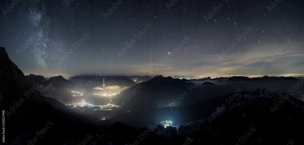 Milky way shot from high above, with the still illuminated city
