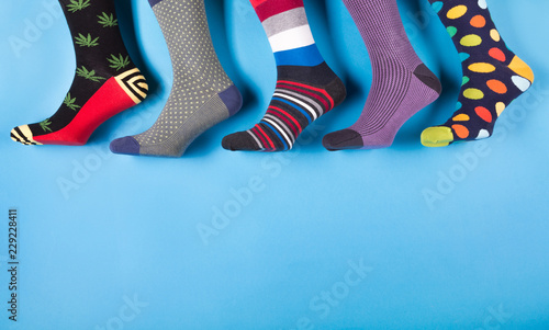 five different men's socks in a row on a pastel blue background, concept photo