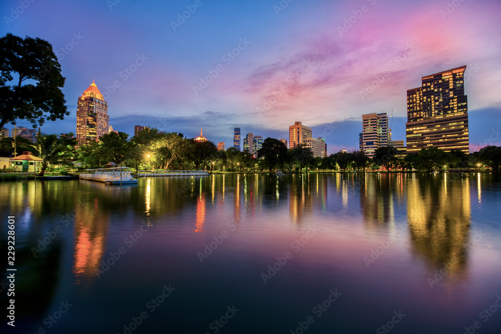 Fototapeta premium Lake view of Lumpini Park in the Thai capital's city centre with buildings in Bangkok