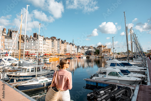 Canvas Print Young woman tourist enjoying beautiful view on the harbour traveling in Honfleur
