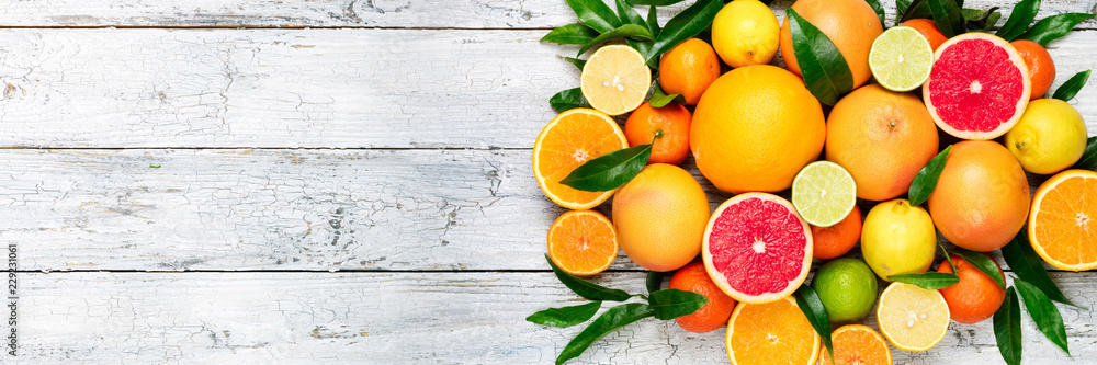 Foto Stock Fresh citrus fruits background. Orange, grapefruit, lemon, lime,  tangerine. Mix citrus fruits with leaves. Long web format. Copy space |  Adobe Stock