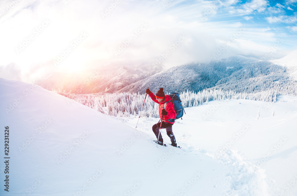 A man in snowshoes in the mountains. A man in snowshoes in the mountains.