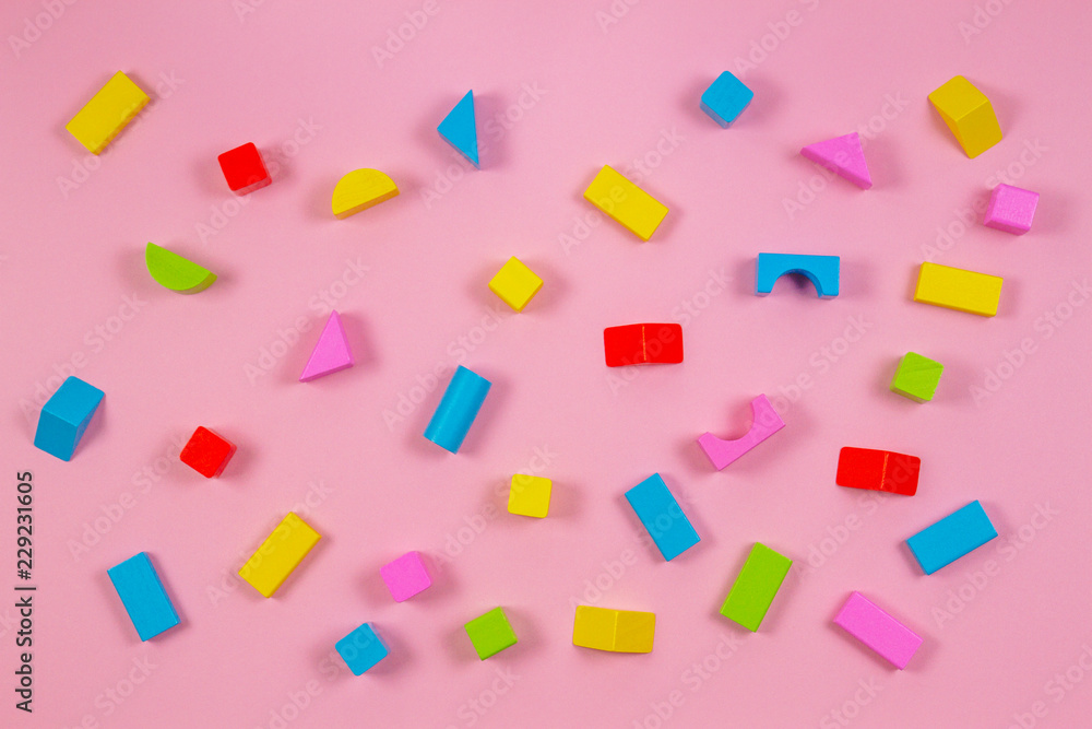 Colorful wooden building blocks on pink background Colorful wooden building blocks on pink background