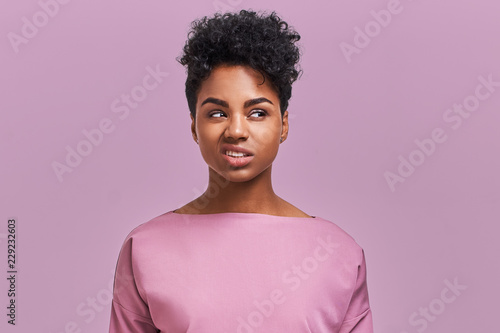 I hate you! Depressed stressful African American female clenched teeth, feels anger because of much work and duties about house, fed up with everything, has quarrel with enemy, poses indoor photo