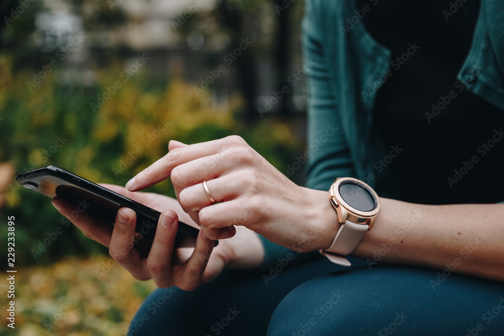 close up of woman using smartphone and smartwatch together. concept of connection.
