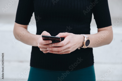 close up of woman using smartphone and smartwatch together. concept of connection. woman wearing a digital watch and typing a text on her phone.