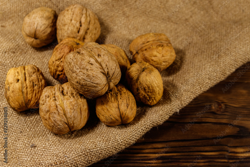 Walnuts on burlap on wooden table Walnuts on burlap on wooden table