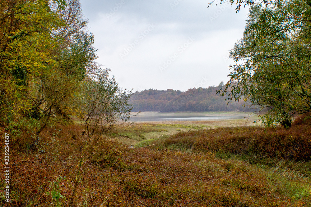 Lake surrounded with forest near the Kragujevac city in Serbia. Cloudy autumn day in sunset. Lake surrounded with forest near the Kragujevac city in Serbia. Cloudy autumn day in sunset.