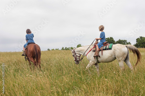 two young girls riding horses