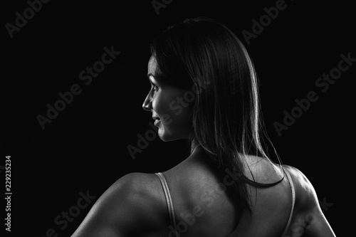 Attractive fitness woman is standing back and looking to side Black and White