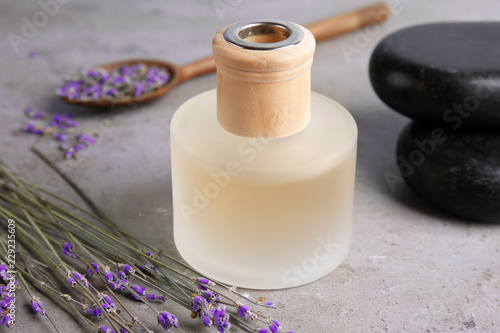 Fototapeta Naklejka Na Ścianę i Meble -  Bottle with natural herbal oil and lavender flowers on color background