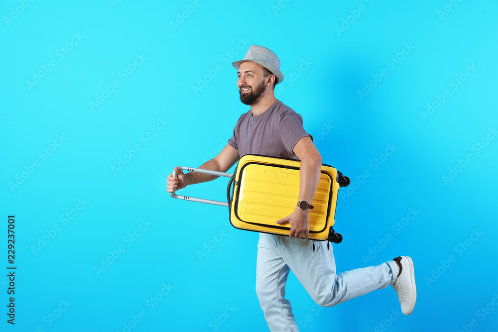 Man with suitcase running on color background. Vacation travel Man with suitcase running on color background. Vacation travel