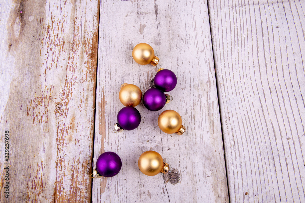 Naklejka premium golden and purple christmas balls on rustic white wood