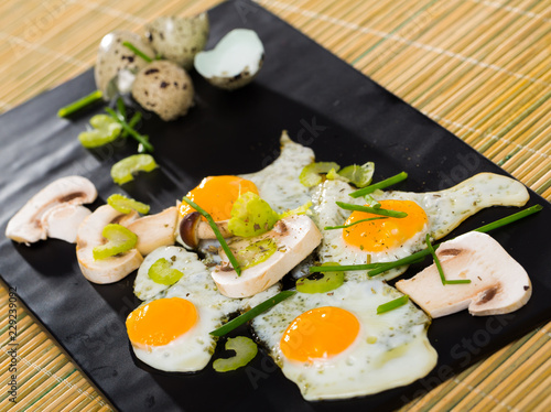 Fried quail eggs with champignons photo