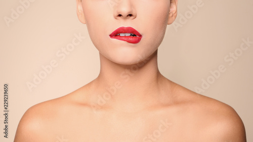 Beautiful young woman with red lips on color background  closeup