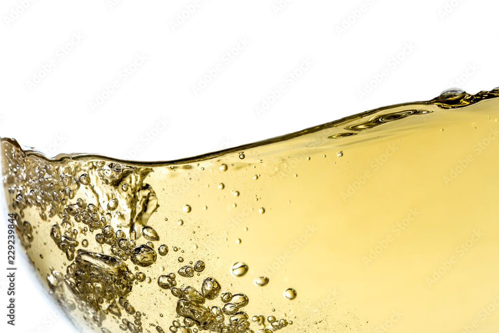 Splash white wine in glass with bubbles close-up macro texture isolated on top on white background. Wave of white wine with beautiful fizz. - obrazy, fototapety, plakaty 