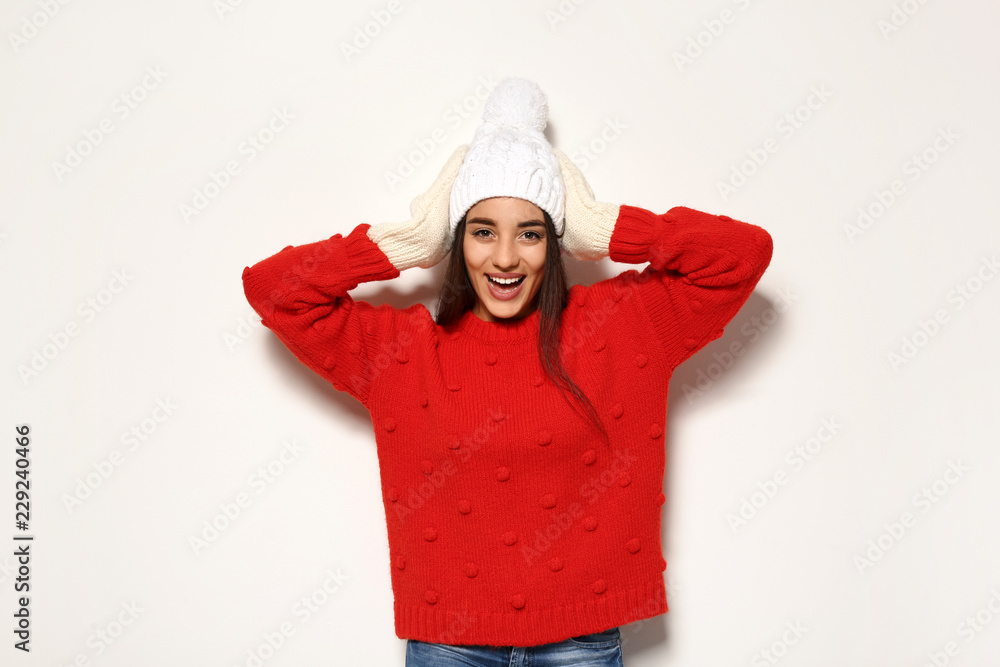Young woman in warm sweater and hat on white background. Celebrating Christmas Young woman in warm sweater and hat on white background. Celebrating Christmas