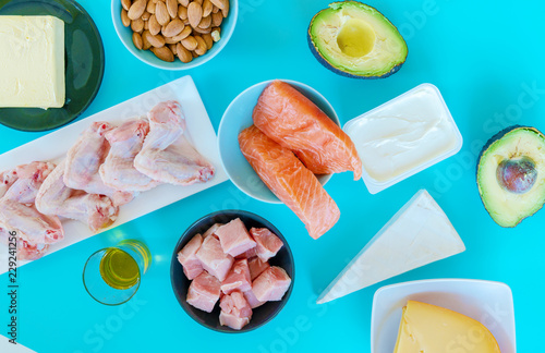 Ketogenic diet food. Low-carb food background, fish, meat, cheese, nuts, oil and butter on a blue background. mockup, flatlay, flat lay Top view Keto diet concept.
