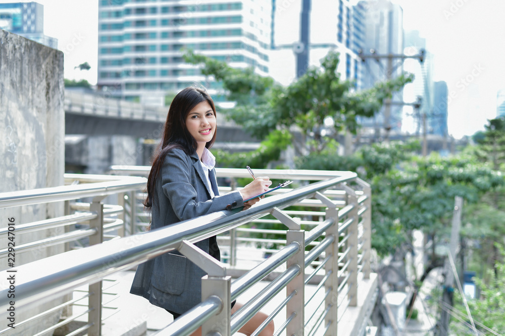 Business concept. Beautiful young businesswoman is working outdoors. Asian girls are working in the business district. Business concept. Beautiful young businesswoman is working outdoors. Asian girls are working in the business district.