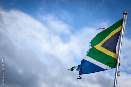 Torn South African flag in the sky waving in the wind