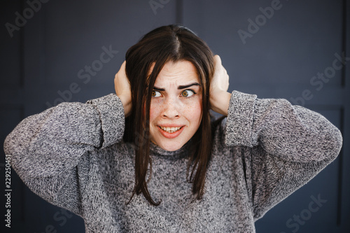 Photos Stressed scared panicked young woman covering ears with hands