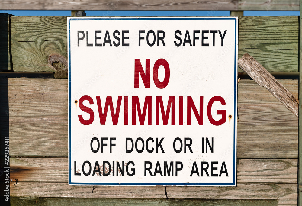 Close view of a no swimming sign on a public pier. Close view of a no swimming sign on a public pier.