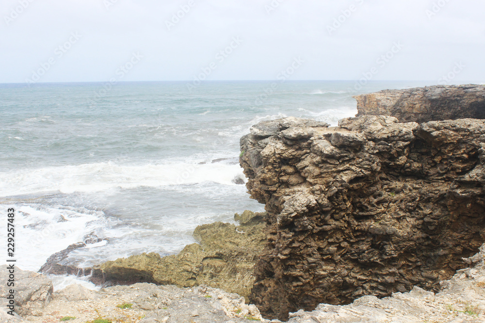 Waves crashing on boulder rock in Barbados