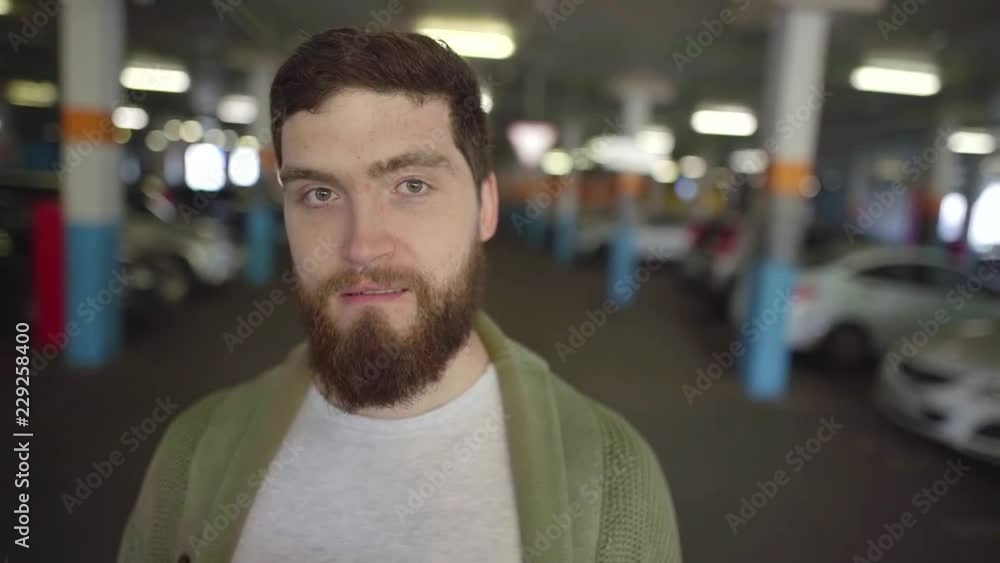 Portrait of a handsome and charming man with a beard on undreground parking lot. Portrait of a handsome and charming man with a beard on undreground parking lot.