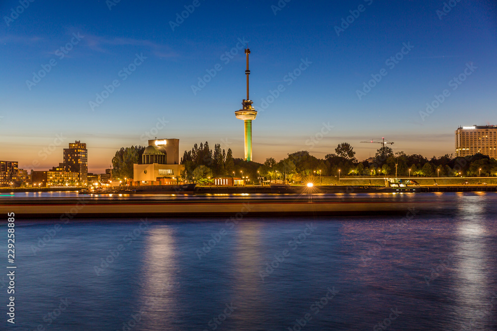 Night cityscape of the New Maas river, the coastal area with lights on and the Euromast tower in the background, quiet night with clear sky in Rotterdam, Netherlands Holland