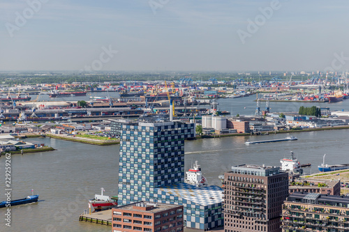 Aerial view of new waterweg with the huge port of Rotterdam in background, cityscape with buildings by riverside against gray cloudy sky, boats sailing in calm water, South Holland in the Netherlands photo