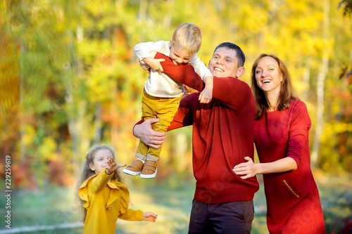 happy family playing and having fun in a beautiful autumn park