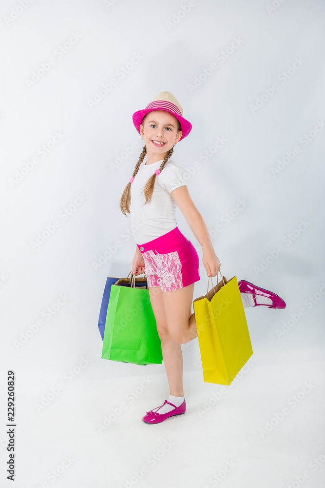 Sale. Cute girl with lots of bags on a white background.