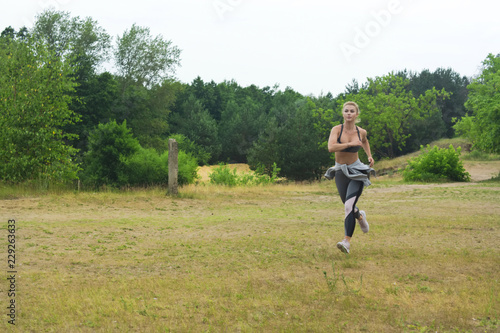 Woman running in green park on summer day