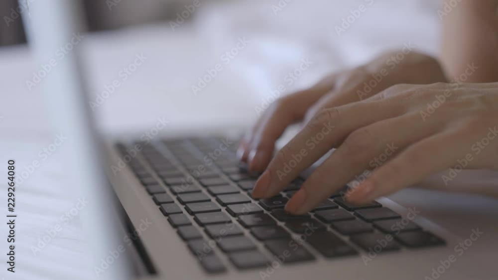 Woman working on laptop in bed Woman working on laptop in bed