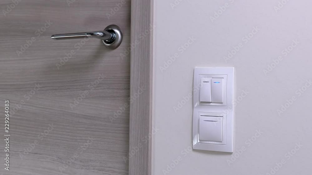 Door handle and white lighting switches at modern apartment Door handle and white lighting switches at modern apartment