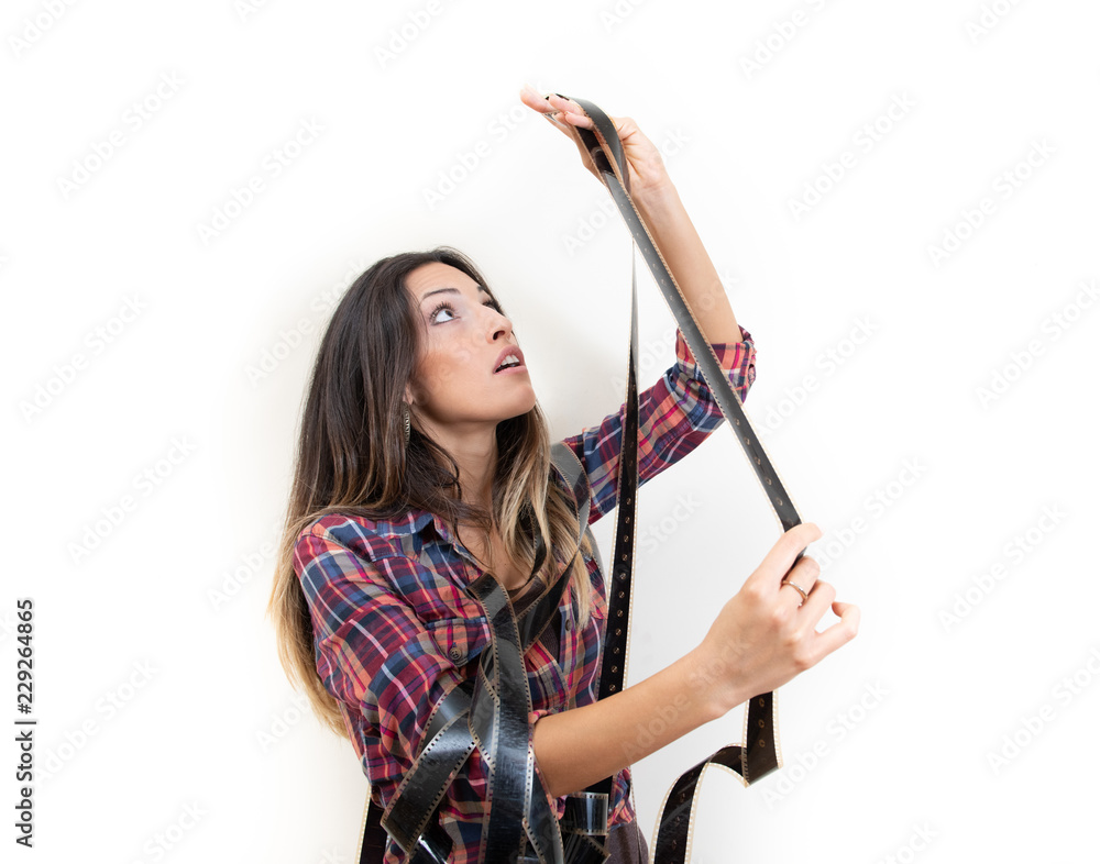 Woman looking at movie reel filmstrip against the light studio shot Woman looking at movie reel filmstrip against the light studio shot