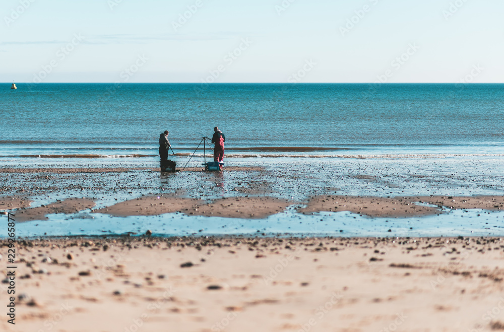 Two men Fishing on Hornsea Beach on a bright day in Autumn 2018