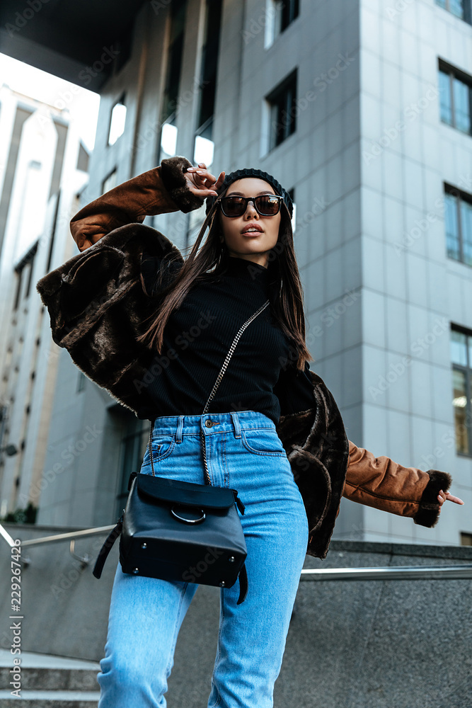 Fototapeta premium City style. Autumn/spring. Woman portrait. Stylish girl in casual clothes and sun glasses, outdoors
