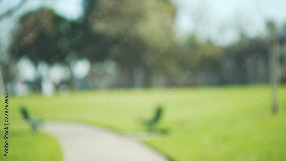 Out of focus background plate of two empty benches in beautiful green park Out of focus background plate of two empty benches in beautiful green park