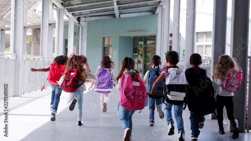 Elementary school kids run from camera in school corridor photo
