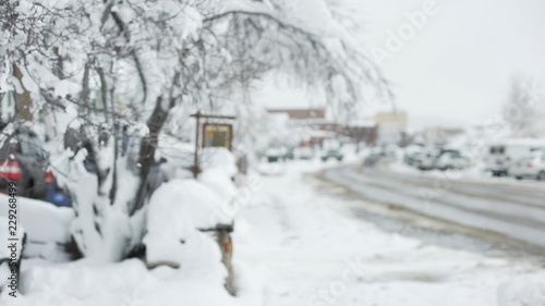 Icy suburban street with a tree covered in snow for background plate © rocketclips